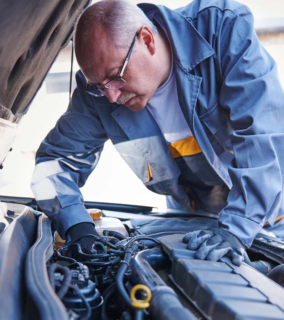 Mechaniker prüft einen Motor bei einem Auto mit Motorschaden für den Motorschaden Ankauf